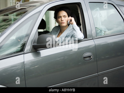 Geschäftsfrau mit Handy im Auto Stockfoto