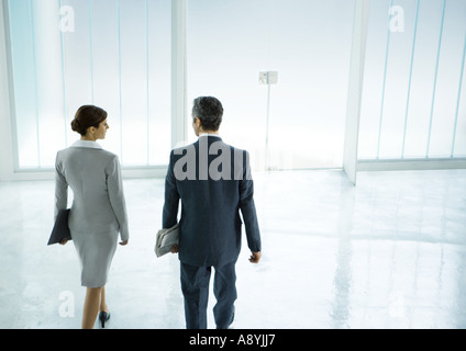 Männliche und weibliche Geschäftspartner zu Fuß in Richtung Tür in lobby Stockfoto