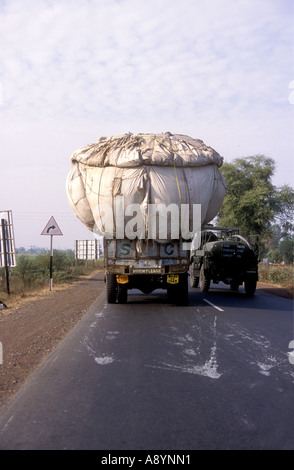 Ein LKW LKW tragen eine große Last auf einer Hauptstraße in Uttar Pradesh Indien A Wasser Tanker ist dabei Stockfoto