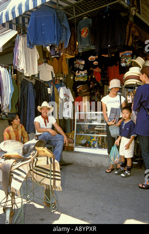 Fachgeschäft mit Market Trader anzeigen Country und Western style Kleidung, Peripherie und Zubehör bei Chatuchak Market, Bangkok Thailand Stockfoto