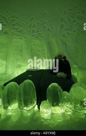 Weibliche Touristen sitzen auf einem Bett in einem der Schlafzimmer ein Eishotel in Lappland, Finnland. Stockfoto