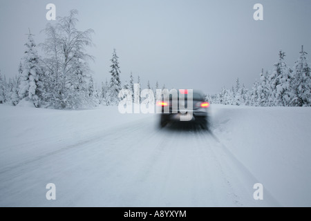 Auto Bremsen auf Schnee bedeckt Straße in arktischen Landschaft Lapplands. Stockfoto