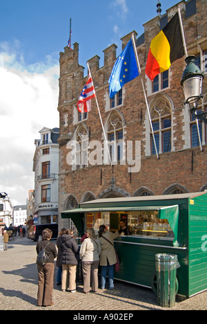 Vertikale Ansicht eines Stalls, der "Frieten" oder Chips mit Mayonnaise vor dem Belfried von Brügge oder Belfort van Brugge in Brügge verkauft. Stockfoto