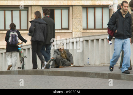 Horizontale Nahaufnahme von einem armen alten Mann sitzen Betteln auf der Ponte di Mezzo in Pisa. Stockfoto