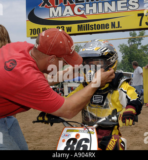 Englishtown, NJ. Raceway Park Motocross Papa hilft 8 Jahr Devin Cooper an Startlinie für 6 8 Jahre Peewee MX Klasse Rennen. Stockfoto