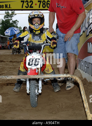 Englishtown, NJ. Raceway Park Motocross Papa hilft 8 Jahr Devin Cooper an Startlinie für 6 8 Jahre Peewee MX Klasse Rennen. Stockfoto