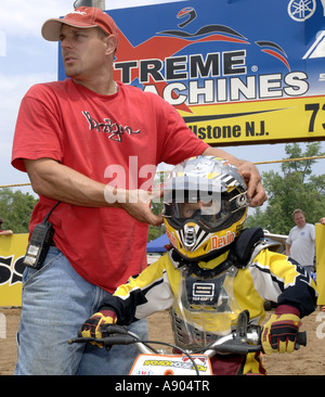 Englishtown, NJ. Raceway Park Motocross Papa hilft 8 Jahr Devin Cooper an Startlinie für 6 8 Jahre Peewee MX Klasse Rennen. Stockfoto