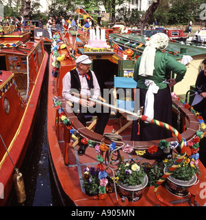 Bunte sonnige Little Venice Kanal Festival festgemacht Narrowboat & in der Nähe Besatzung in traditionellen Kostümen Paddington Basin London England GB Stockfoto