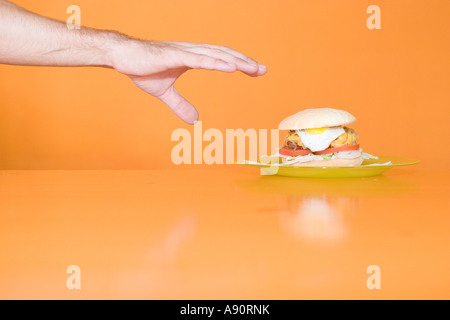 Hand greift, um hausgemachte Burger Stockfoto