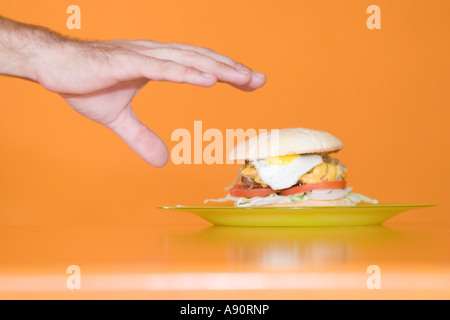 Hand greift, um hausgemachte Burger Stockfoto