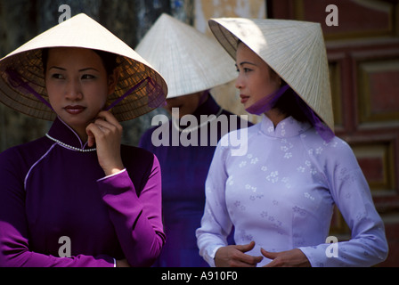 Hübsche Mädchen tragen traditionelle Kostüme und die ikonischen konischen Hüte In Vietnam Stockfoto