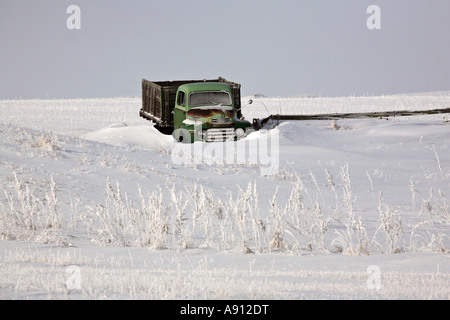 Alter Bauernhof LKW geparkt in schneebedeckten Feld Stockfoto