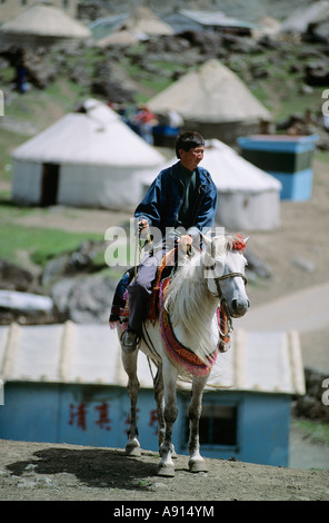 Kasachischen Hirten sitzen auf Pferd mit Jurte Dorf im Hintergrund, See des Himmels, Provinz Xinjiang, China Stockfoto