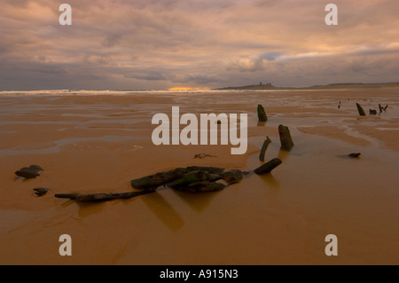 Hölzernes Schiffswrack Embleton Bay mit Dunstanburgh Castle am Horizont Northumberland UK Stockfoto