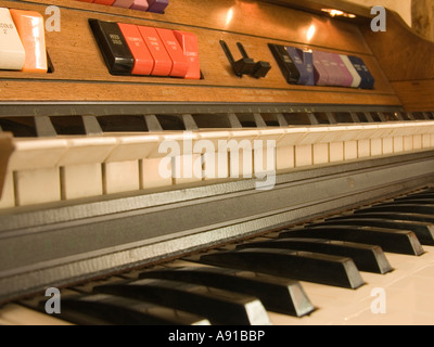 Eine doppelte manuelle Organ elektronisches Klavier mit vielen Knöpfen.  Dies ist ein Vintage Holz Möbelstück. Stockfoto