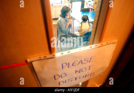 Schule Berater spricht leise, ein Kind mit nicht stören Schild an Tür Stockfoto