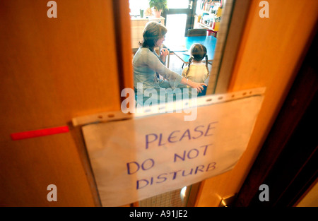 Schule Berater spricht leise, ein Kind mit nicht stören Schild an Tür Stockfoto