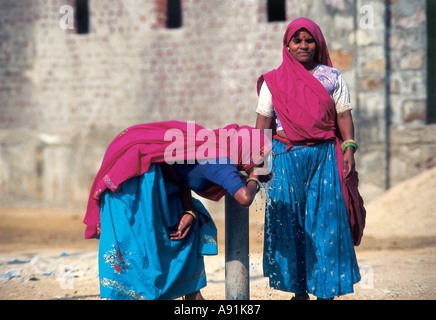 NMJ99687 Dorf Frau Trinkwasser aus Bohrloch Tap Rajasthan Indien Stockfoto