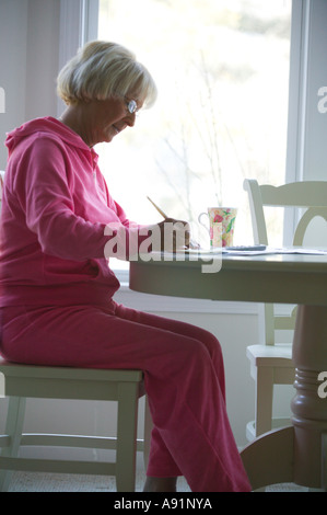 Ältere Frau zahlt Rechnungen Stockfoto