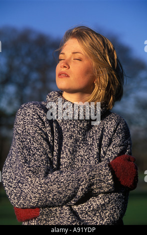 Frau genießen einige Wintersonne auf ihrem Gesicht Stockfoto