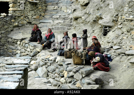 Gruppe von Frauen in traditionellen Wollkleid sitzen auf einer Mauer Phu Nar-Phu Annapurna Region Nepal Stockfoto