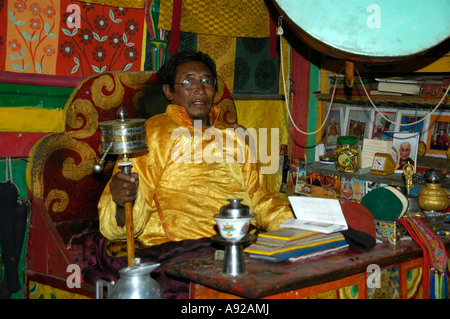 Mönch Lama Sonom gekleidet in einen gelben Umhang drehen eine Gebetsmühle im Kloster Tashi Gompa Phu Nar-Phu Annapurna Region Nepal Stockfoto