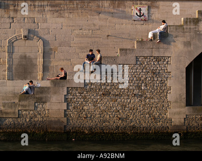 Fußgänger, die sitzen am Seine-Ufer, Paris, Frankreich Stockfoto