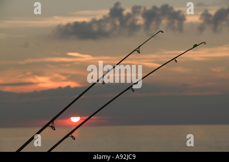 Angeln Ruten auf Weybourne Strand Norfolk bei Sonnenuntergang Stockfoto