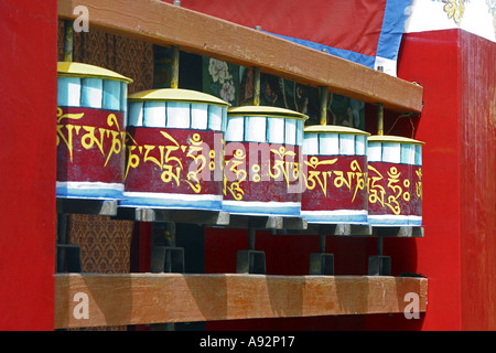 5 buddhistischen Gebet Trommeln oder Räder aus Holz, hell rot lackiert, mit goldgelben Tibetischer Inschrift "Om Mani Padme Hum". Stockfoto