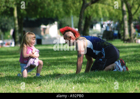 Mann mit roten Irokesenschnitt Haarschnitt mit einem blonden Kind spielen Stockfoto