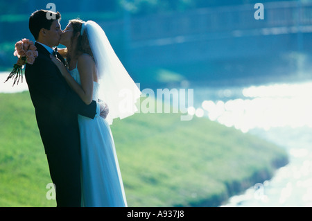 Seitenansicht von einem frisch verheirateten Paar küssen einander Stockfoto