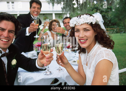 Porträt von einem Brautpaar sitzen mit ihren Eltern und Hochzeitsgäste Stockfoto