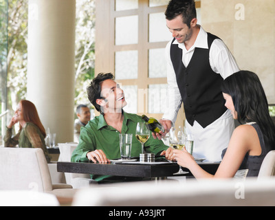 Kellner gießt Wein für paar im Restaurant unter freiem Himmel Stockfoto