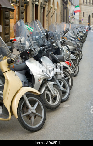 Vertikale hautnah aus einer Reihe von vielen Mopeds und Motorroller geparkt am Straßenrand in Florenz. Stockfoto