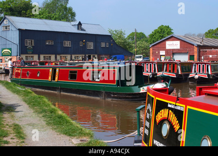 Schmale Boot vorbei an ankern Boote bei Wrenbury Mühle und Werft am Llangollen Kanal bei Wrenbury Cheshire Stockfoto