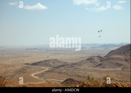 Zwei Gleitschirmflieger driften über einen trockenen Tal aus dem Spreetshoogte Pass Namib Naukluft Nationalpark Namibia Stockfoto