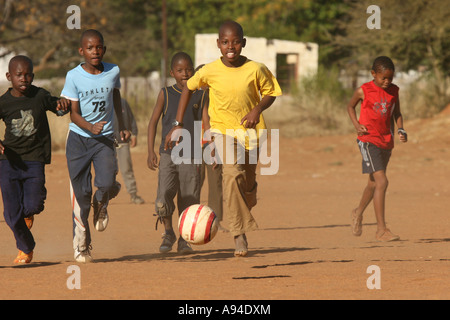 Jungs spielen Fußball auf einem staubigen Fußball Feld Gaborone, Botswana Stockfoto