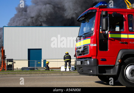Kabine der Feuerwehrwagen mit Feuerwehr außerhalb unter Rauchsäule am Feuer bei medizinischen Lager coleraine Stockfoto