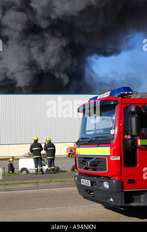 Kabine der Feuerwehrwagen mit Feuerwehr außerhalb unter Rauchsäule am Feuer bei medizinischen Lager Coleraine vertikale Stockfoto