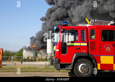 Feuerwehrauto geparkt im Vordergrund, wie Feuerwehrleute loderndes Feuer am medizinischen Lager Coleraine anzugehen Stockfoto