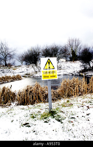 Gefahr tiefe Wasser neben gefrorenen Teich in der Landschaft Stockfoto