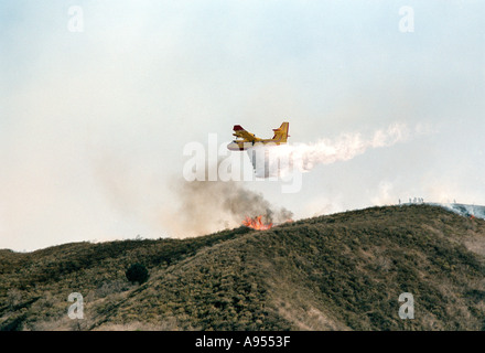 Feuerwehr Flugzeug Tropfen Wasser auf ein Buschfeuer in Kalifornien als Rauch steigt Stockfoto