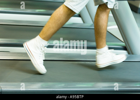 Mann läuft auf Laufband, Knie abwärts, verschwommen Bewegung Stockfoto