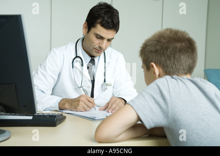 Arzt gegenüber Kind Patient, Notizen Stockfoto