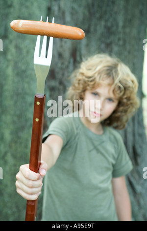 Junge Hot-Dog am Ende des großen Gabel halten Stockfoto