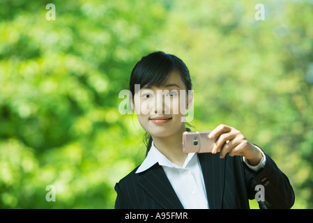 Junge Frau mit Schalltrichter, lächelnd in die Kamera Stockfoto