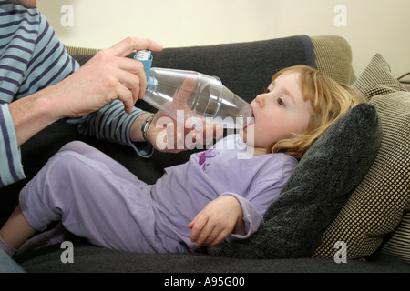 junges Kind leidet an Asthma mit Vater mit Salbutamolinhaler durch einen Vernebler Stockfoto