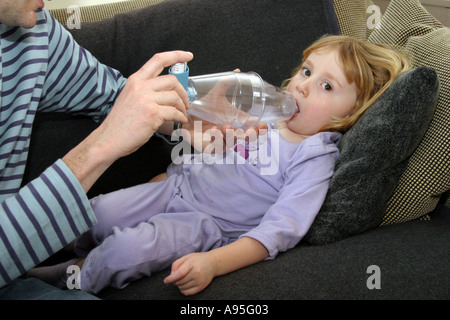 junges Kind leidet an Asthma mit Vater mit Salbutamolinhaler durch einen Vernebler Stockfoto