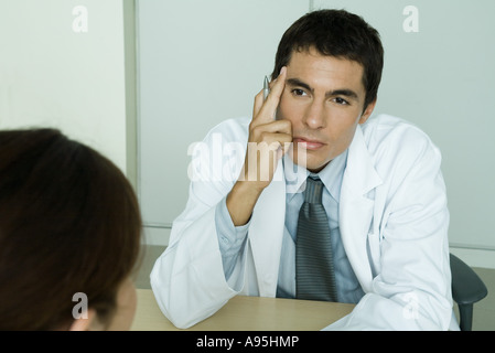 Arzt gegenüber Patientin sitzt Stockfoto