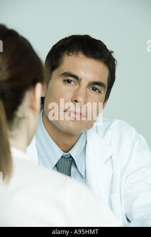 Arzt gegenüber Patientin sitzt Stockfoto